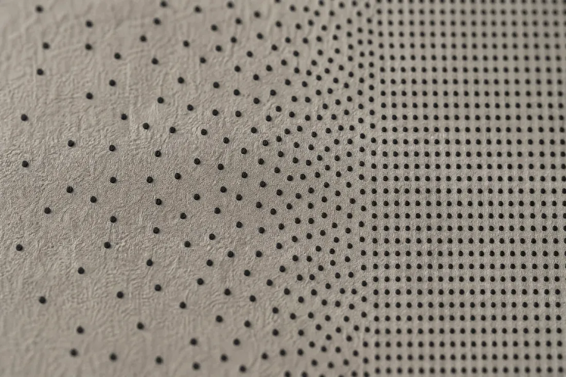 Un nuage de points d’encre désordonnés qui se résout progressivement en grille régulière.